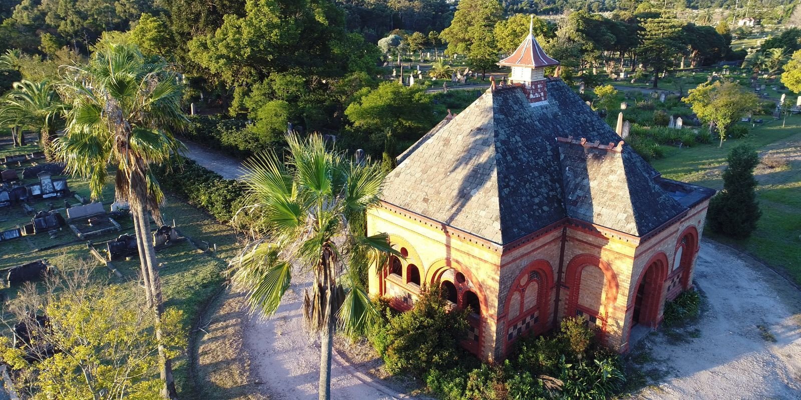 Aerial view of a historic building in a lush cemetery, symbolising connection and remembrance at Metropolitan Memorial Parks.