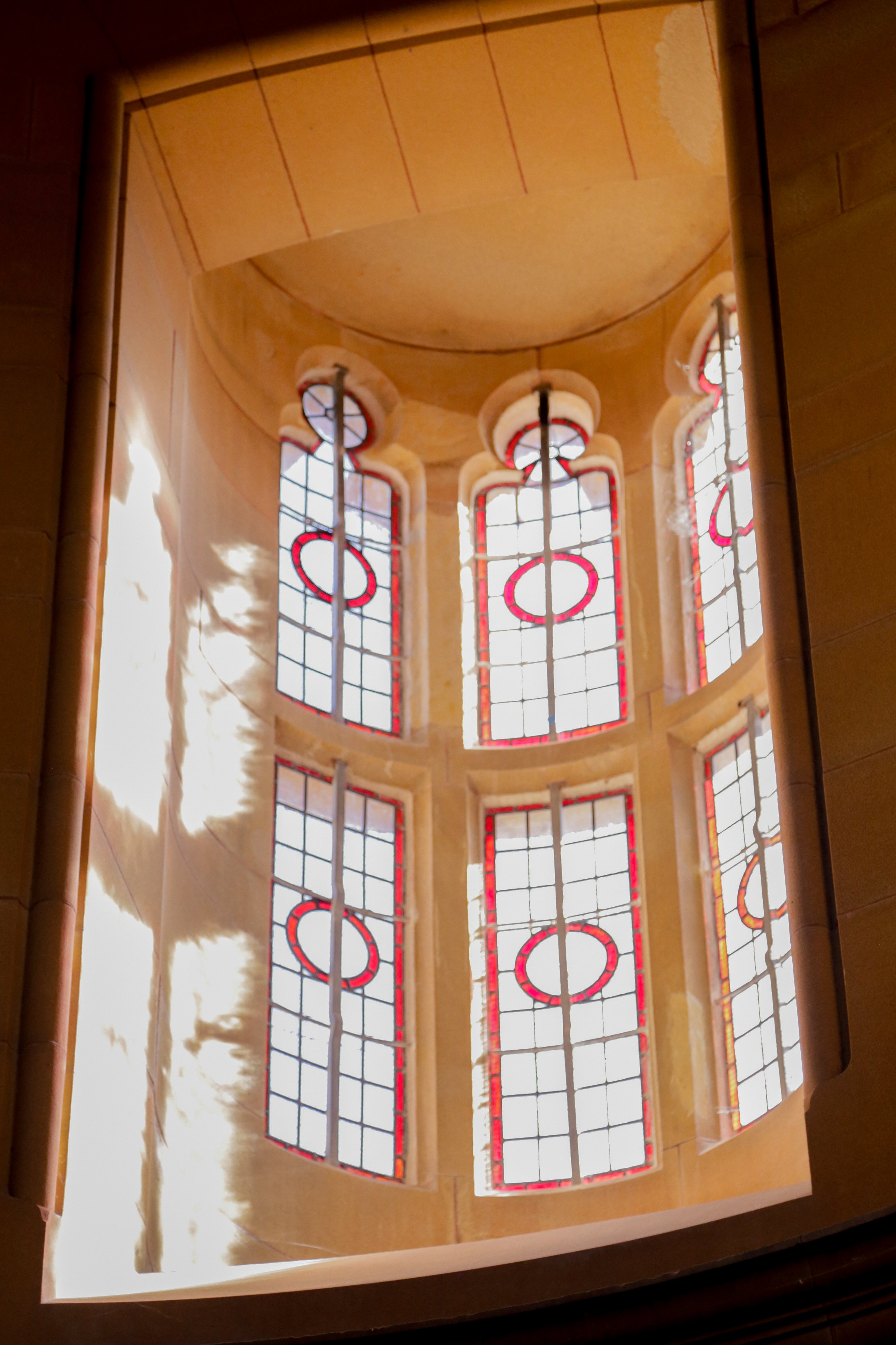 stained glass window with sun streaming through creating a reflection on the wall